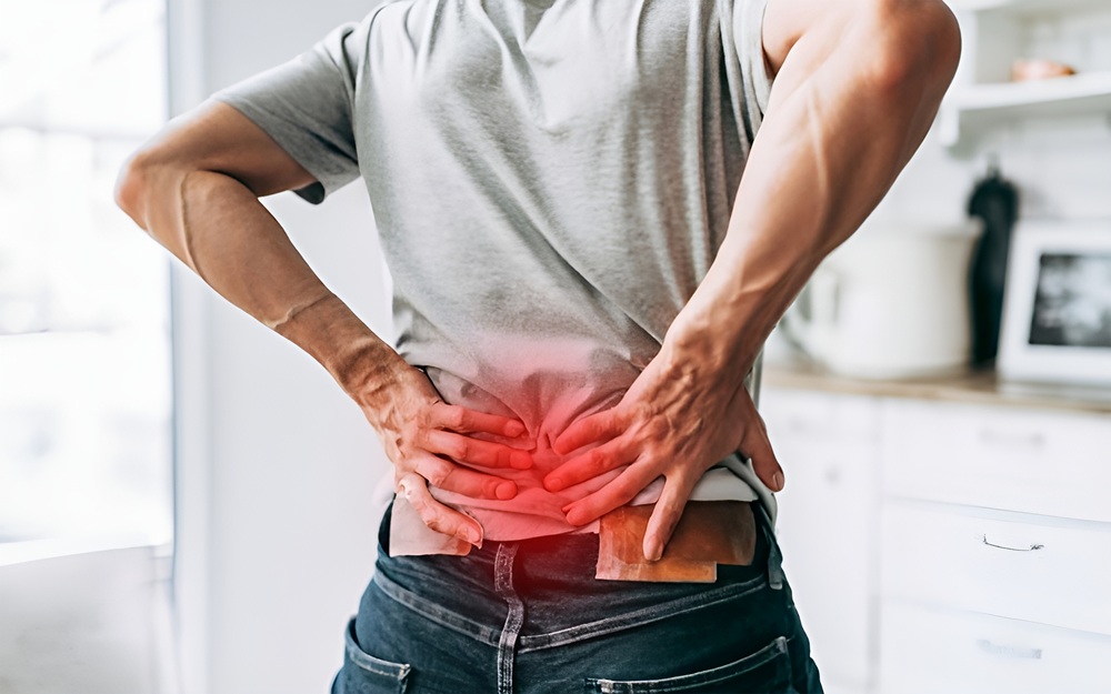 A person holds their lower back in visible discomfort, with a red glow effect emphasizing inflammation and acute pain commonly treated through pain management care – Pain Management Hendersonville TN.